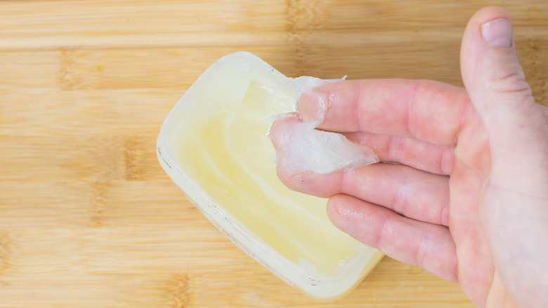 Hand scooping out Vaseline