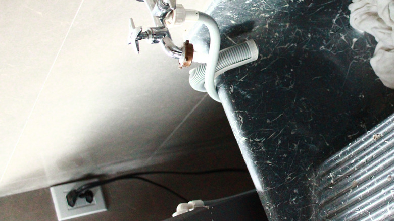 a utility sink with a hose and valves