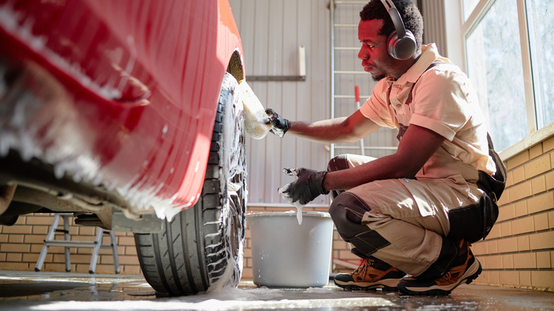 young person cleaning vehicle tires