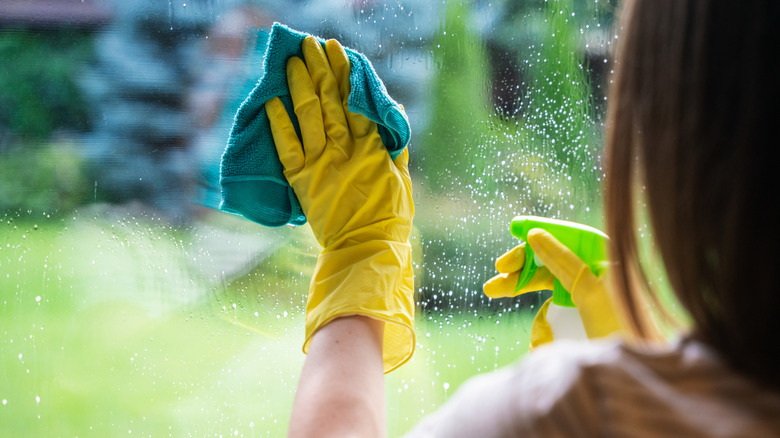 person washing windows with a cloth