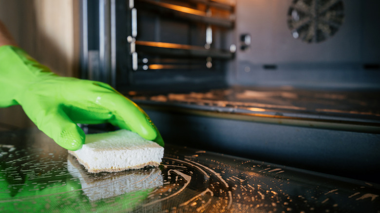 person scrubbing oven