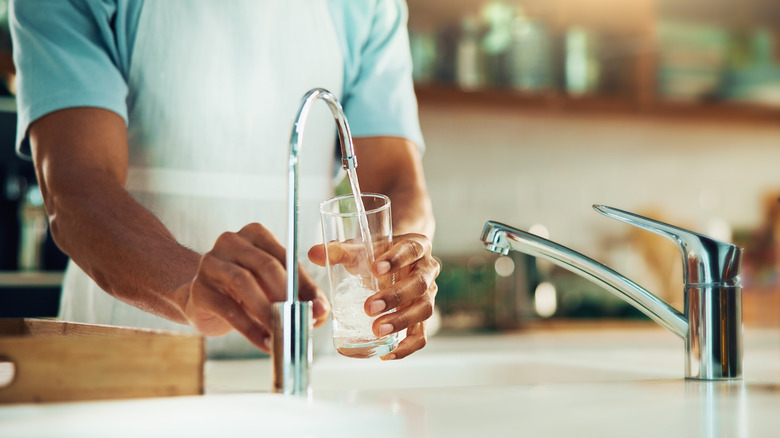 person pouring filtered water