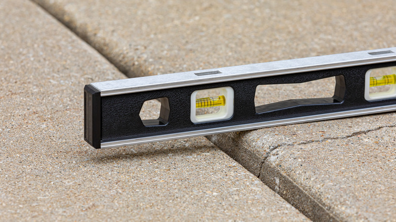 View of a level on top of a driveway, a slight crack undeneath