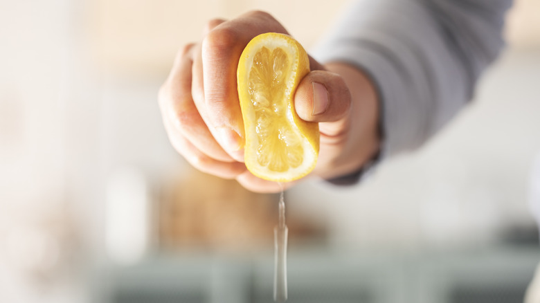 Hand squeezing a lemon