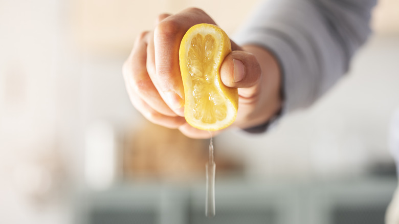 hand squeezing juice from lemon