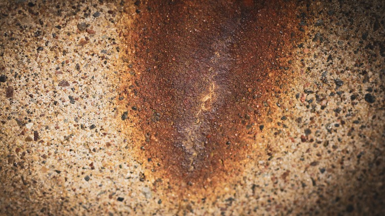 Closeup of rust on an aggregate driveway