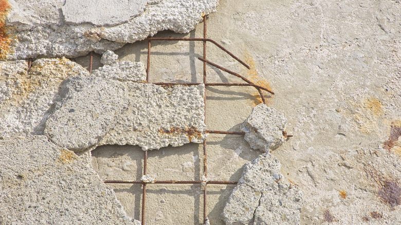 Pieces of concrete broken away showing rusty wire reinforcement