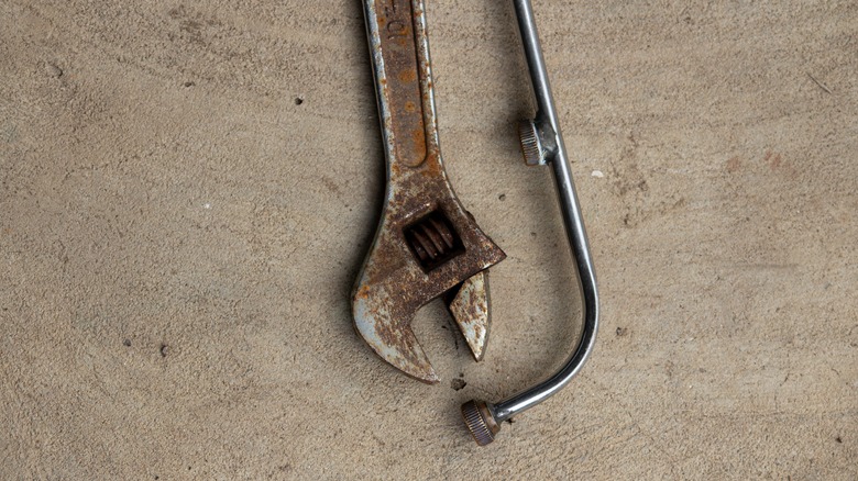 View of a rusty wrench on a concrete