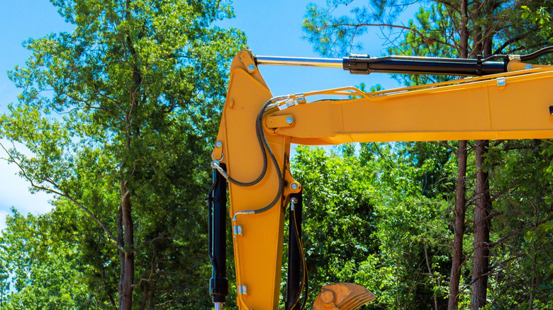 A digger in action helping to build a large concrete block retaining wall