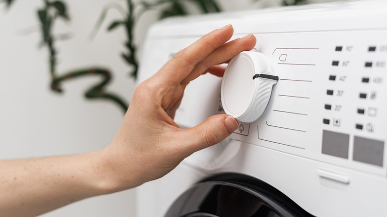 hand selecting washer cycle