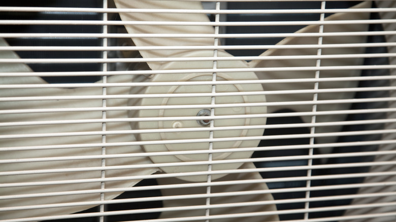 An attic fan is seen under the roofline from outside