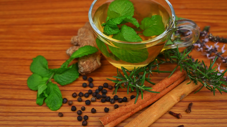 Peppermint and cinnamon sticks are among the herbs set out on a cutting board