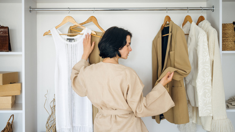 Woman picking clothes from her capsule wardrobe