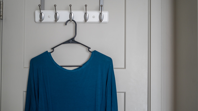 Blue scoop neck top hanging on door