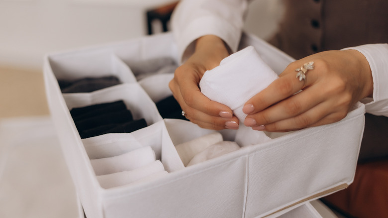 Drawer dividers with folded up socks in each compartment.