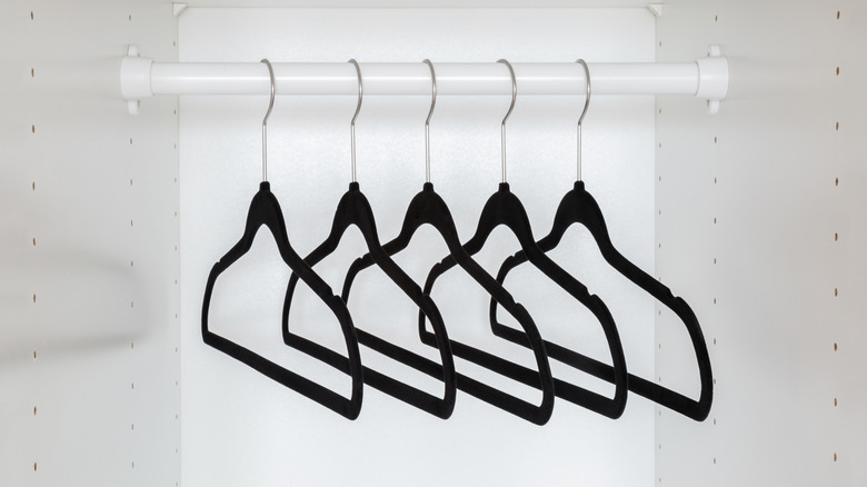 Black velvet hangers hanging in an empty closet