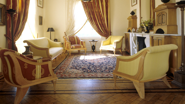 Bold burnt orange and sheer curtains add interest and warmth to a small sitting room.