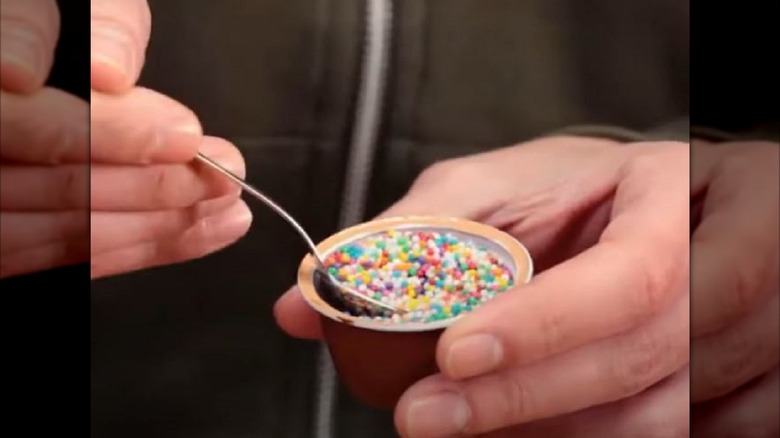 Man eating chocolate dessert out of coffee pod