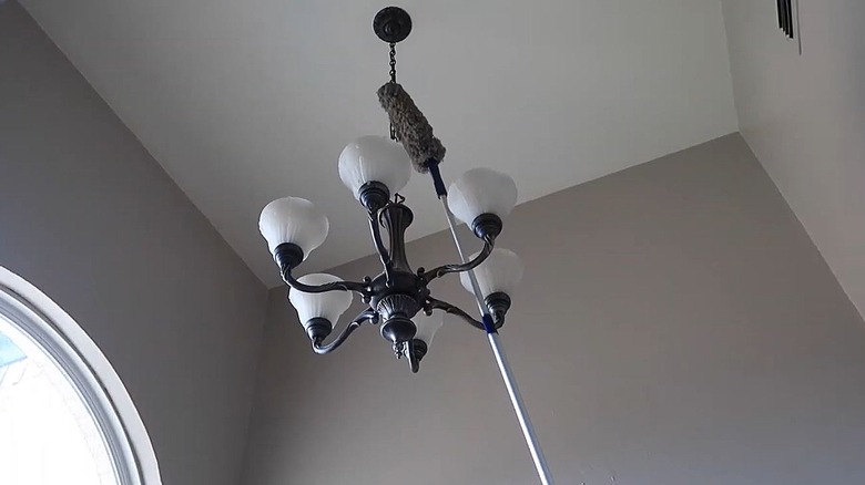 A telescoping duster reaches a light fixture on a high ceiling.
