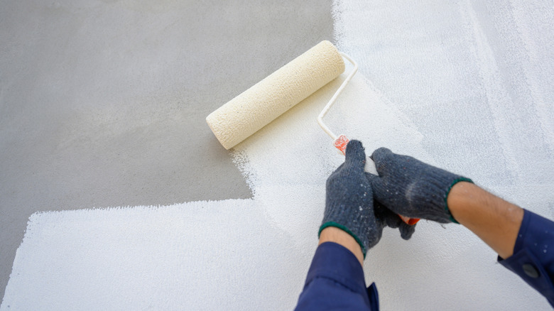 hands priming an exterior