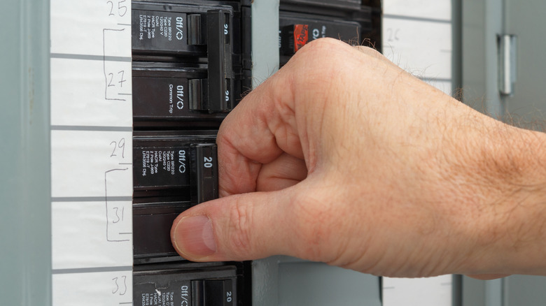 Man's hand on a circuit breaker