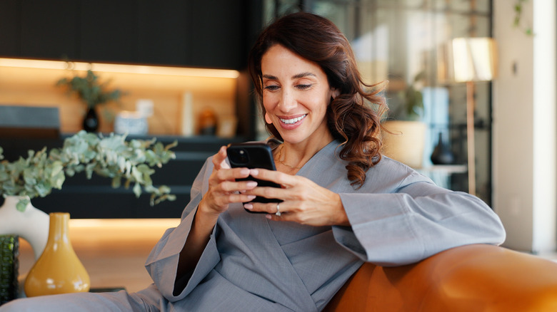 woman on couch browsing phone