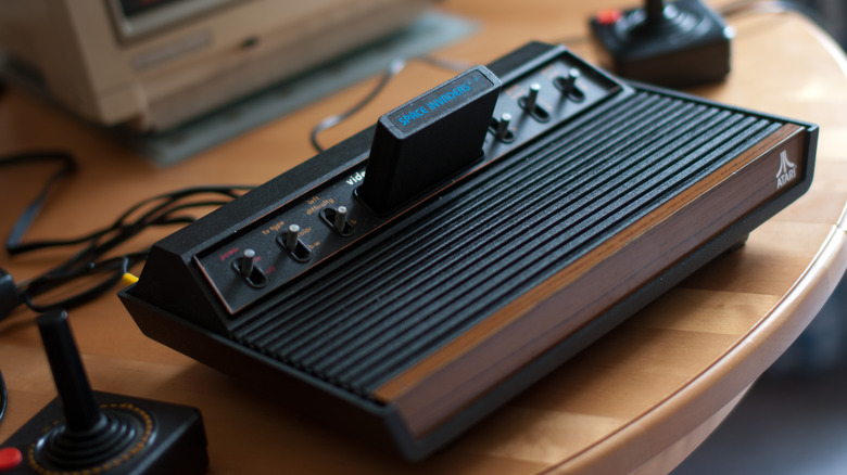 Atari VCS (heavy sixer) 1977 model with controllers on table Space Invaders cartridge inserted