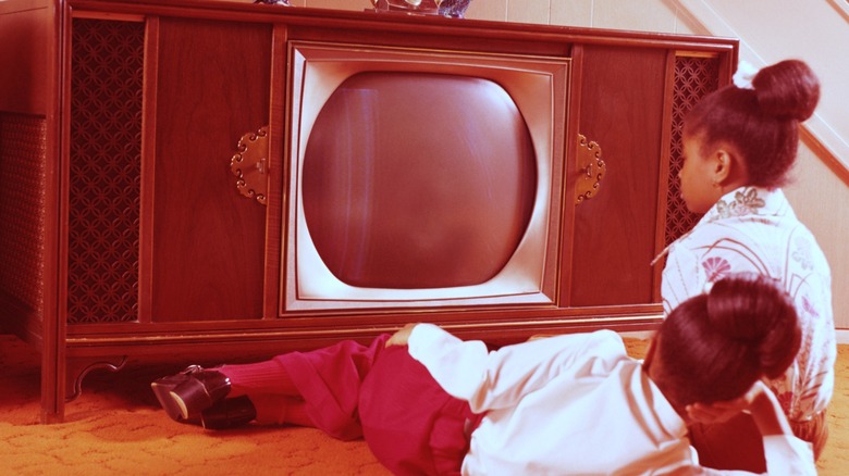 Giant 1970s console TV with two young girls watching
