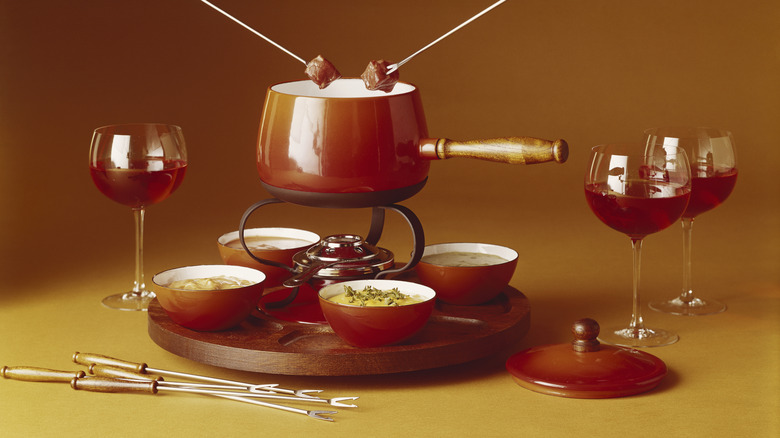 Table with fondue set and glasses of wine