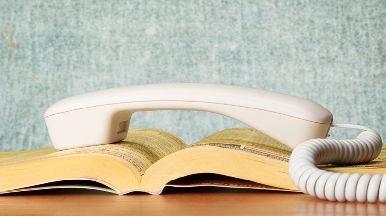 Telephone on top of a telephone book on a table