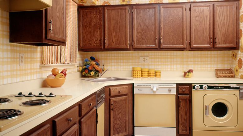 Kitchen from the '70s with wooden cabinets and yellow wallpaper