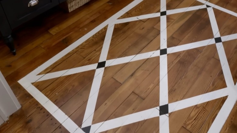 A white and black diamon design painted on wood floors.
