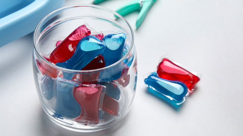 A small glass jar full of laundry detergent pods