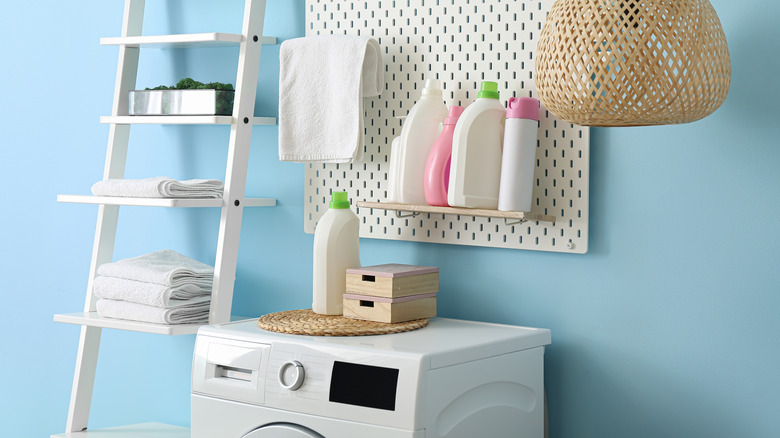 A laundry room with pegboard and ladder storage
