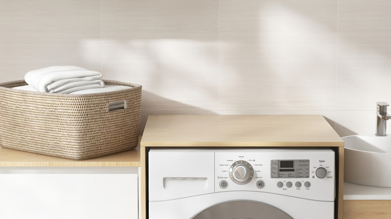 A washing machine with a light brown countertop