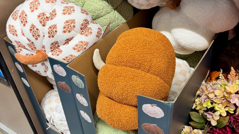 Pumpkin shaped pillows in various patterns on display at an Aldi aisle