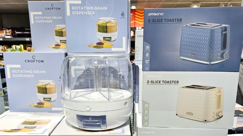 Aldi Crofton rotating grain dispenser and 2-slice toaster packages stacked in department store aisle.