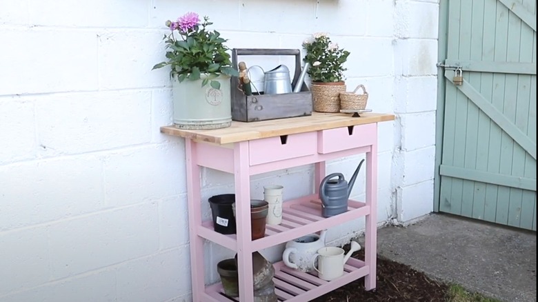 Pink wooden cart used as potting bench