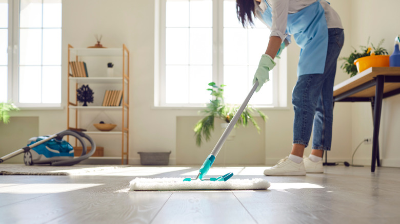 Person using a push mop on a hard floor