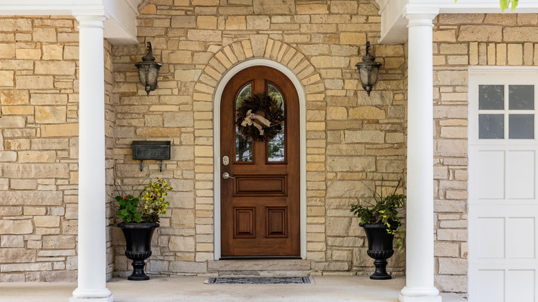 wooden front door on stone wall of home