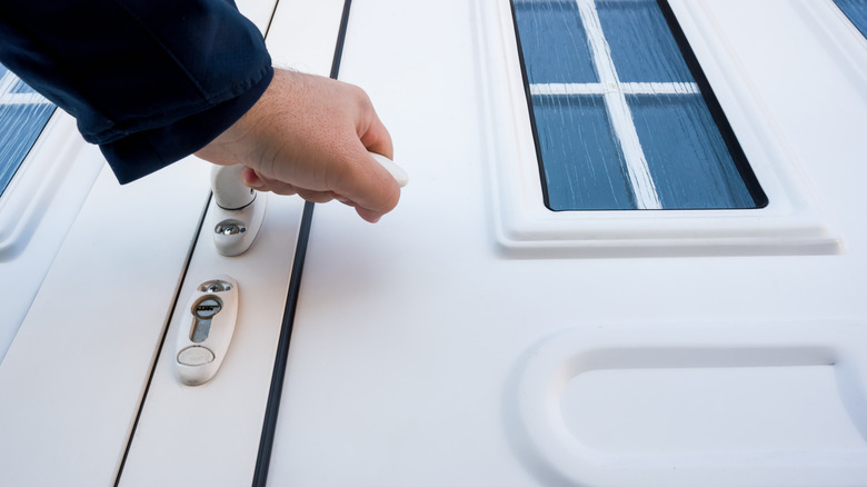 hand on knob of uPVC front door