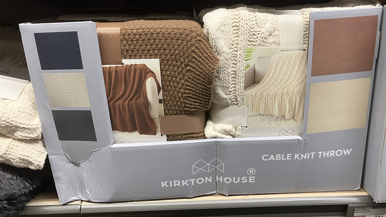 Cable knit throws in white and brown, in a box labeled Kirkton House.