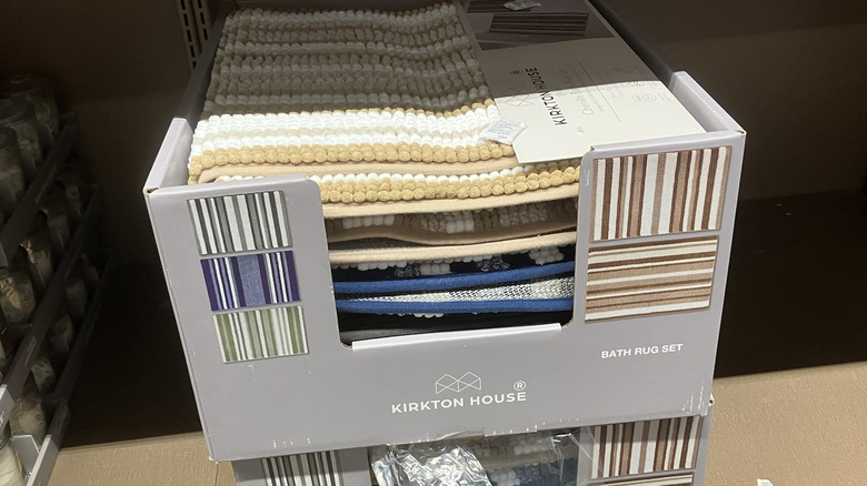 Striped bath rugs on display in a box at Aldi.