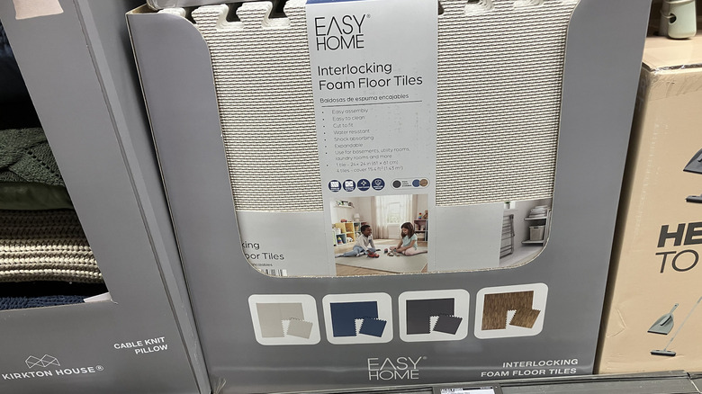 White foam floor tiles on display in a box at Aldi.