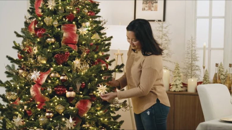woman decorating the Balsam Hill Christmas tree