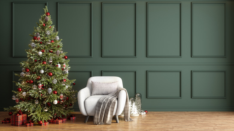 Christmas tree against a green paneled wall