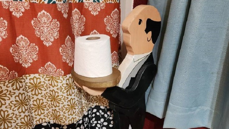 Thrifted butler statue holding toilet paper