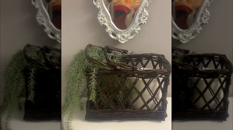 Wicker basket in bathroom filled with toilet paper and a plant