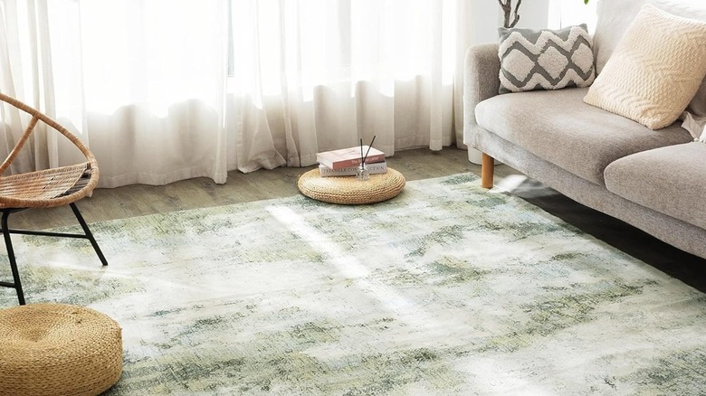 A living room with an earthy green area rug