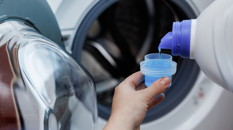 Pouring laundry detergent into a cup